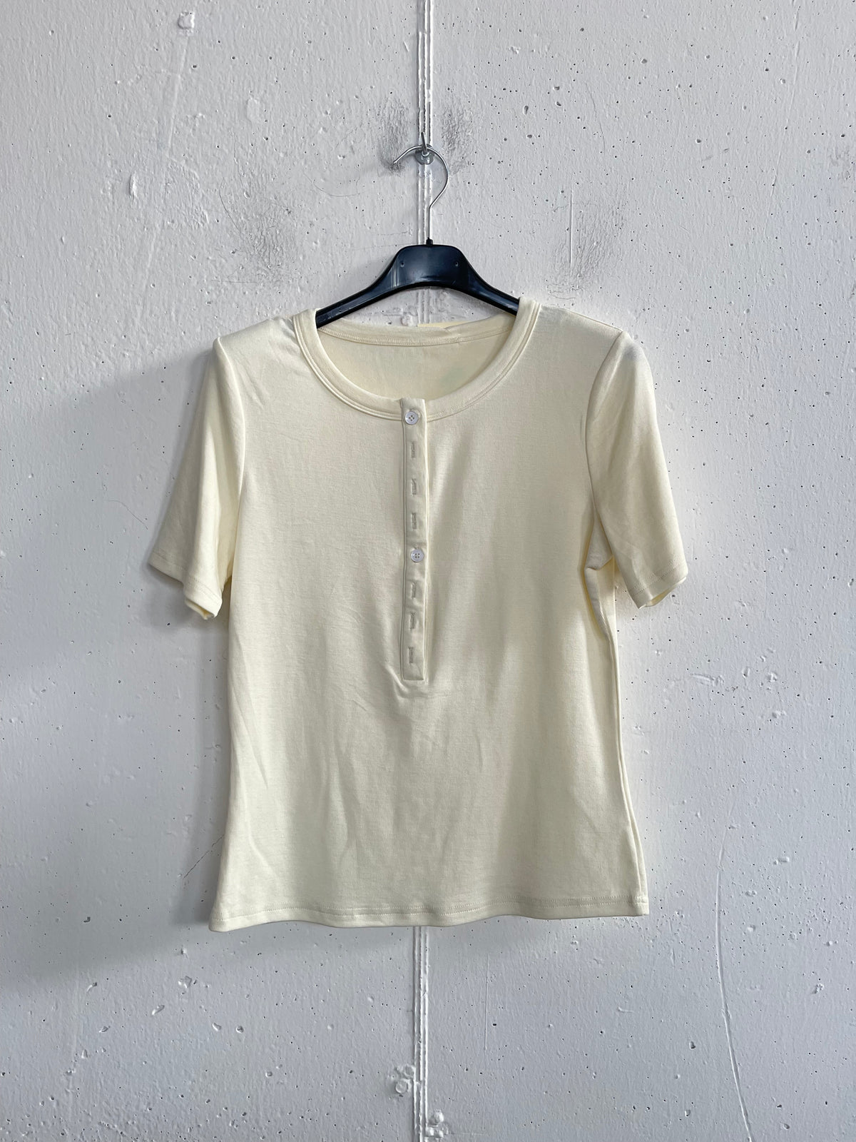 T-shirt con bottoncini e spalline imbottite