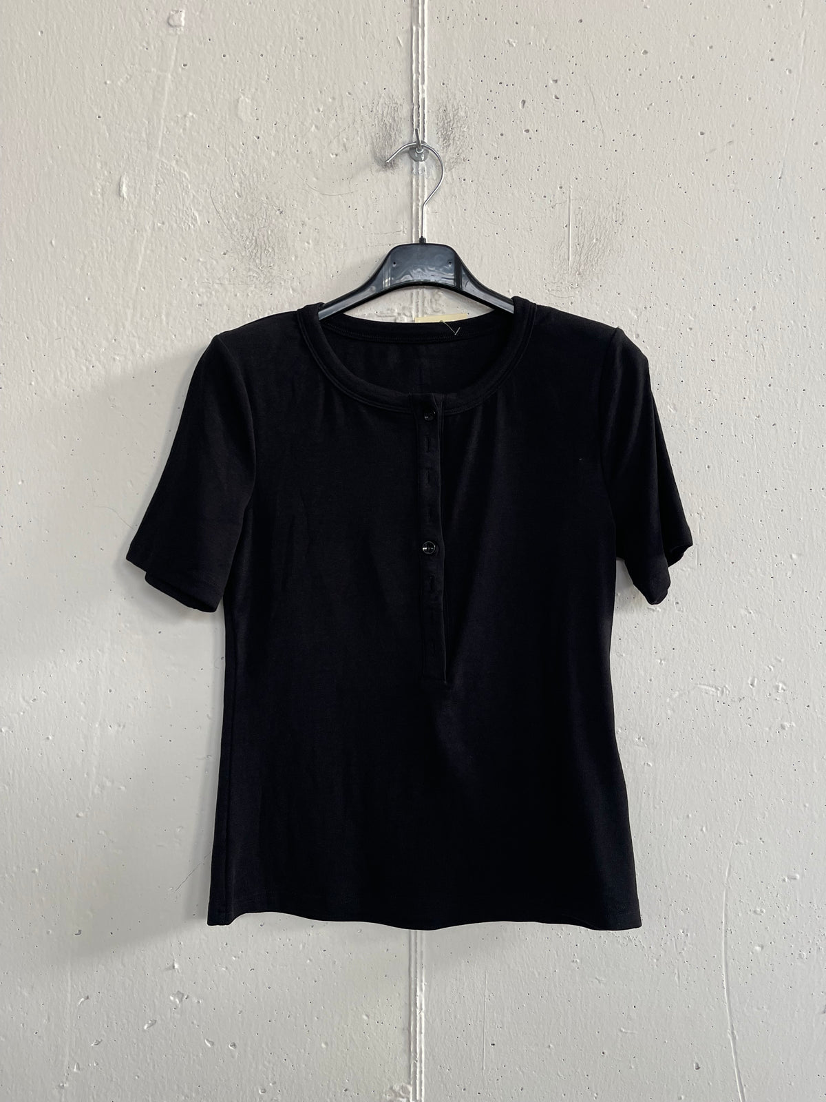 T-shirt con bottoncini e spalline imbottite